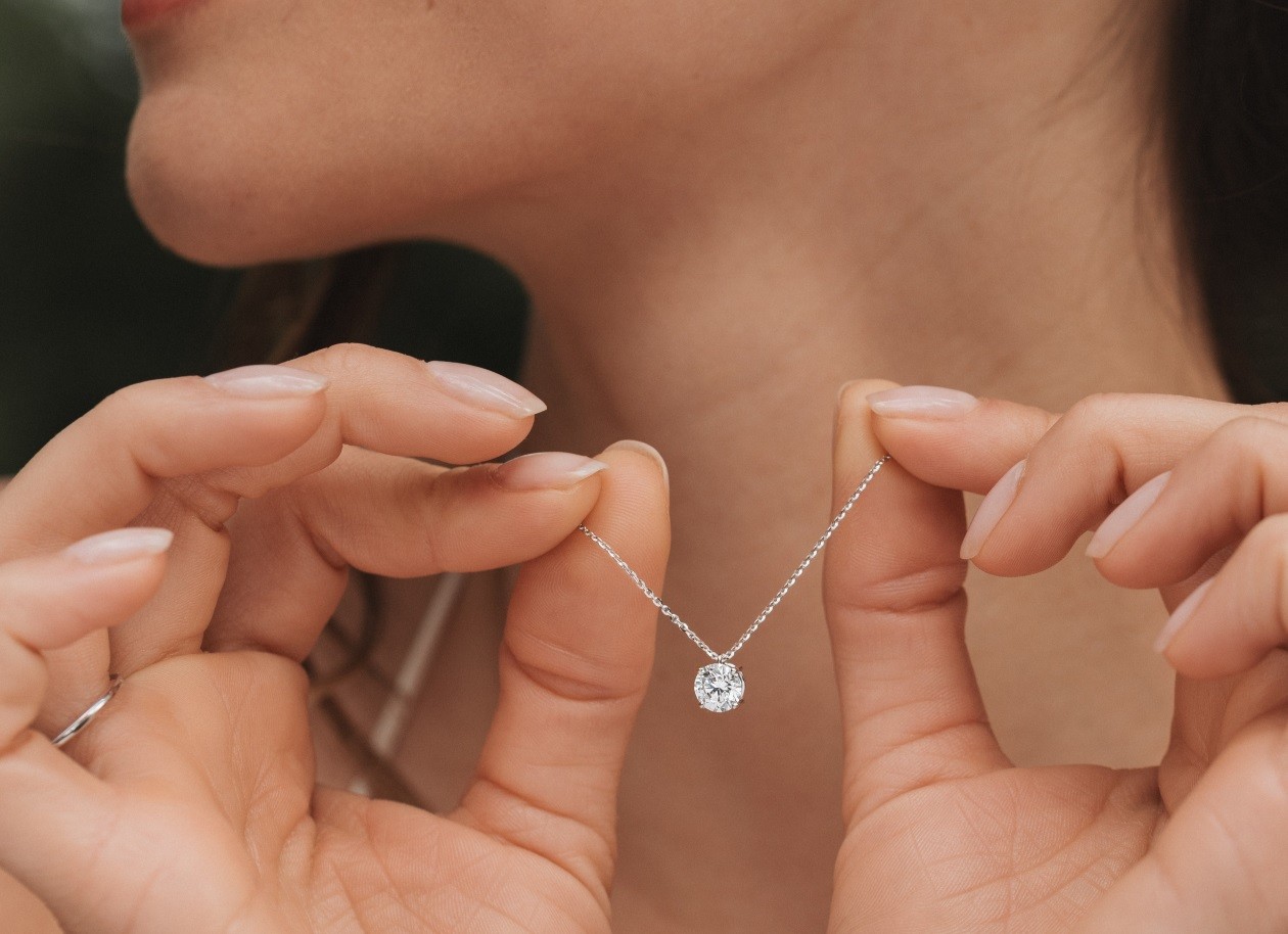 Diamond necklace held by a woman 
