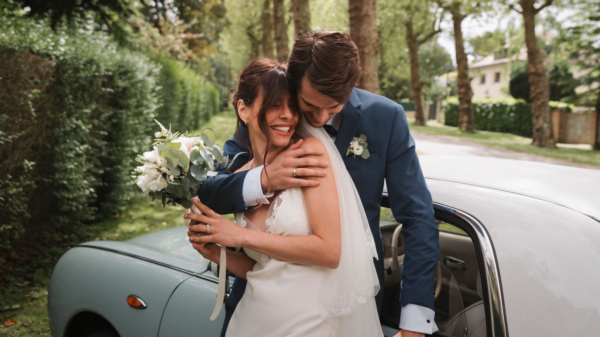 married couple in front of a car wearing lepage gold and diamond jewellery 